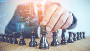 A man in a suit situating a chess piece in a strategic move symbolizing an advisor creating an Investment Gameplan for their client.