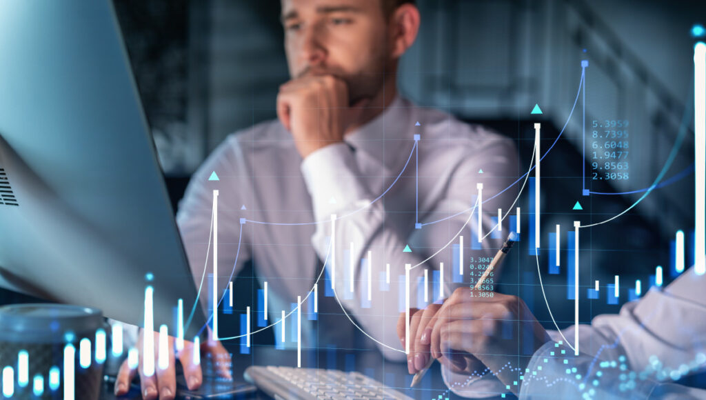 A graph overlay illustrating rising rates and inflation with a wealth management team working on a plan to improve their clients’ portfolios.