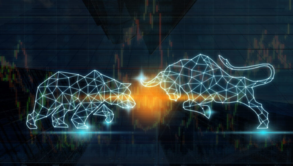A digital bull and bear are colliding on top of a market chart.